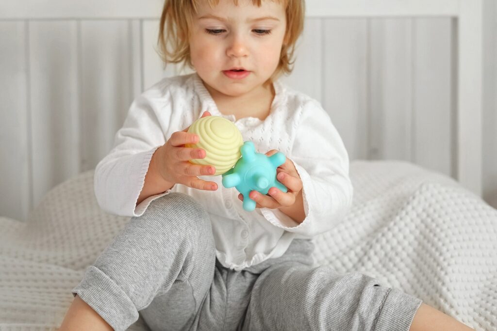 Toddler playing with toys showing tactile skills