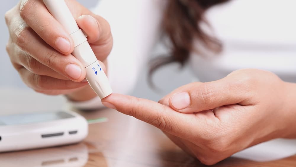 person testing insulin with finger tester
