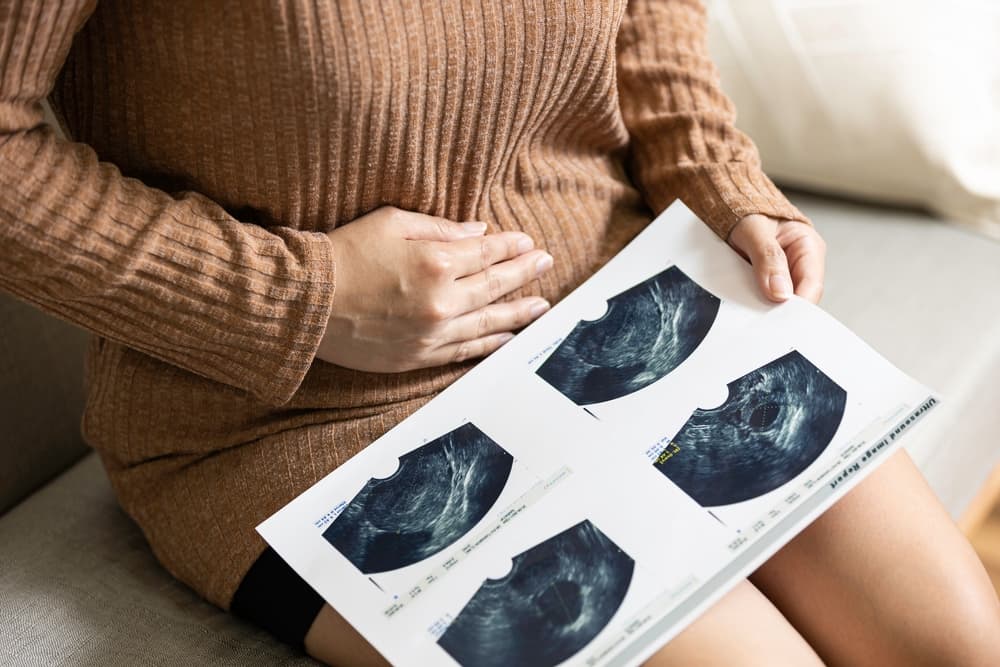 woman in pain looking at uterus sonogram