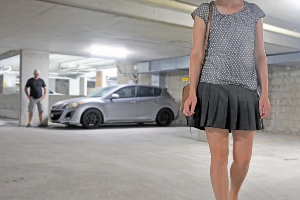 A woman walks nervously away from her Uber while the male driver watches - Lawsuit Legal News - Uber Sexual Assault Lawsuit