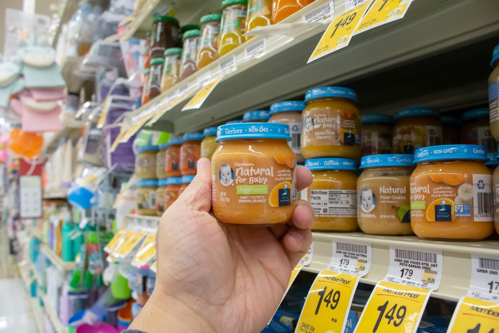 Person holding jar of Gerber carrot baby food - Gerber Toxic Heavy Metal Baby Food Lawsuit - Lawsuit Legal News