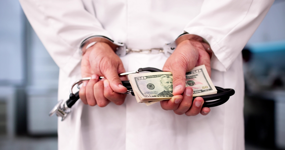 doctor in cuffs with money over fraud - numale medical malpractice and fraud lawsuits.jpg