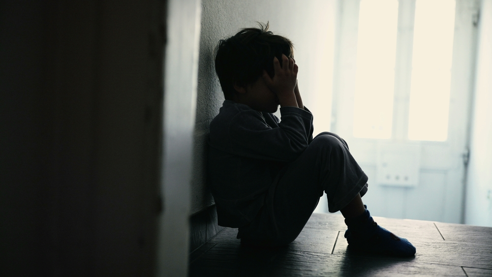 silohette of young boy expressing sadness in group home
