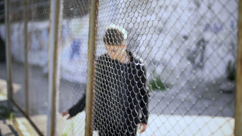 teen boy behind fence in New Hampshire juvenile detention center representing sexual abuse